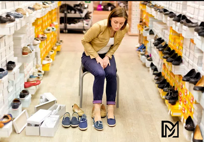 خانمی در مغازه کفش فروشی در حال انتخاب کفش برای مقاله انتخاب سایز کفش مناسب